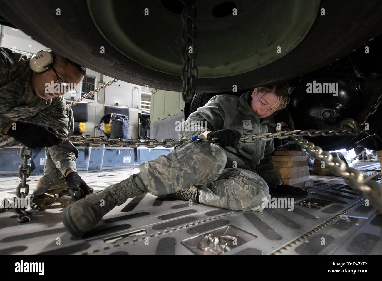 (Right to left) U.S. Air Force Airman 1st Class Ashley Dennis and A1C Galdamez Moran, 730th Air Mobility Squadron air freight technicians, secure a tie-down chain on a Japan Air Self-Defense Force electric power plant vehicle Nov. 6, 2016, at Yokota Air Base, Japan.  This was the first time to an EPP vehicle was loaded onto an USAF aircraft. U.S. military and JSDF members conducted training with their Japan Self-Defense Forces counterparts during the Keen Sword 2017 at military installations throughout Japan, the Mariana Islands and in the surrounding waters. (U.S. Air Force photo by Yasuo Osa Stock Photo