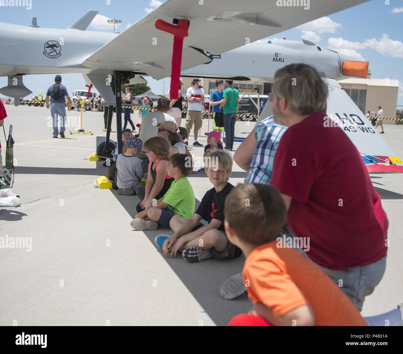 Visitors at the Kirtland Air Force Base Air Show rest in the shade of an MQ-1 Predator on June 5. Over 50,000 people visited the Kirtland AFB Open House June 4 and 5. Holloman Airmen had the opportunity to display an MQ-1 Predator and answer questions visitors had about RPAs and their mission at Holloman. (U.S. Air Force photo by Airman 1st Class Randahl J. Jenson) Stock Photo