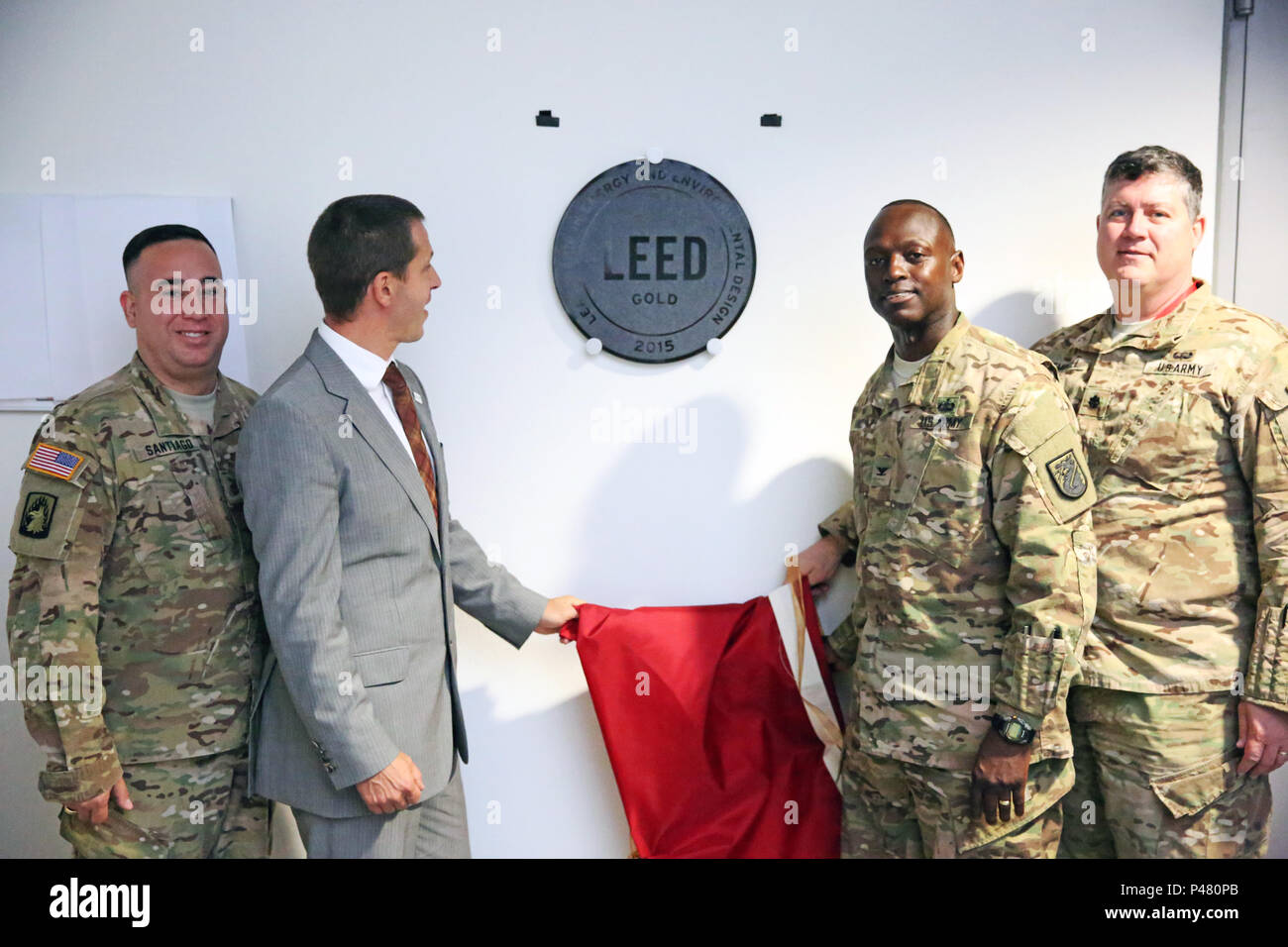 U.S. Army Maj. Roberto Santiago, Gray Cyber Center director of operations; Kay Killmann, president of the German Green Building Association; Col. Jimmy L. Hall Jr. commander of 5th Signal Command (Theater) and the U.S. Army Europe chief information officer/G-6; and Lt. Col. Charles Hemphill, U.S. Army Corps of Engineers - Europe District deputy commander, unveil a LEED Gold plaque June 27, 2016 at the Lt. Gen. Robert E. Gray Cyber Center Europe in Wiesbaden, Germany. The Gray Center is the first Department of Defense building in Europe and the first throughout the U.S. Army Network Enterprise  Stock Photo