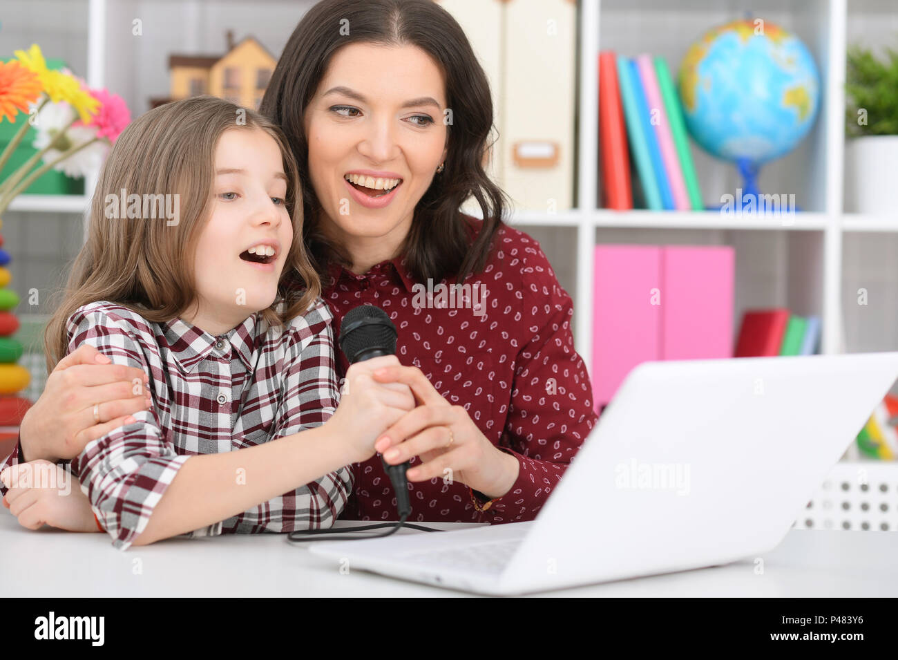 mother and daughter singing karaoke Stock Photo Alamy