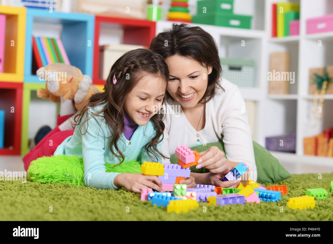 Cute girl playing with plastic blocks Stock Photo - Alamy