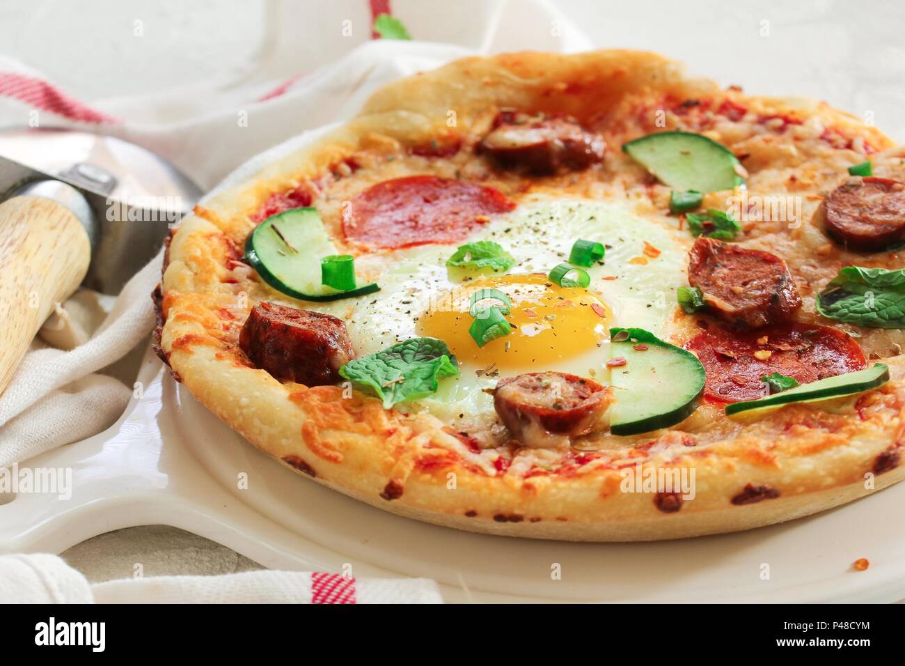 Homemade breakfast Pizza with fried egg pepperoni and veggies Stock