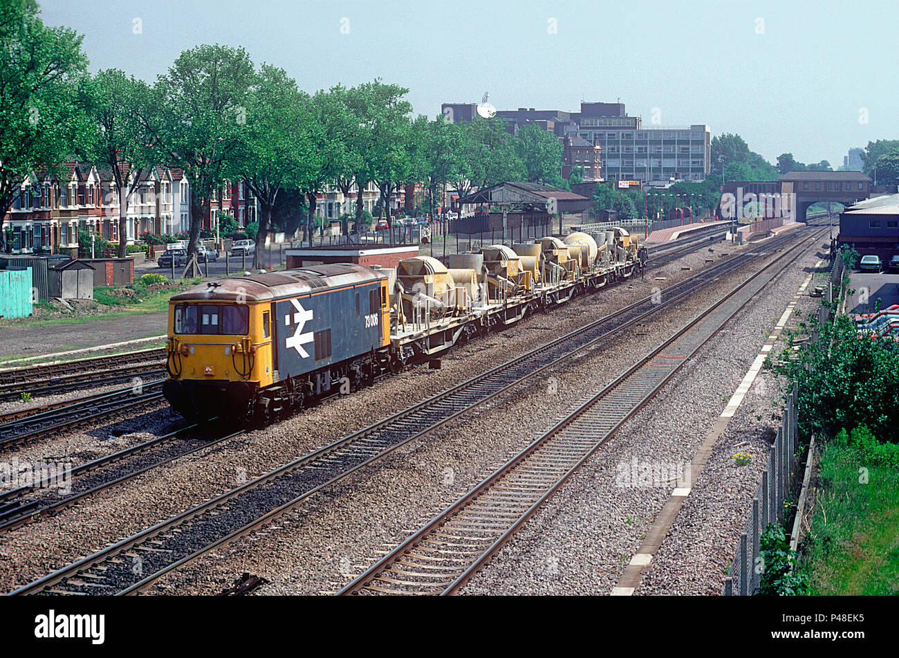 A class 73 JA electro diesel locomotive number 73006 heading down the Great Western Main Line with a departmental working consisting of cement mixers mounted on bogie flats at West Ealing on the 20th May 1992. Stock Photo