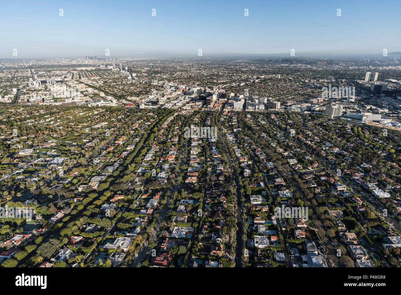 Afternoon aerial view of Beverly Hills streets with mid Wilshire and downtown Los Angeles California in background. Stock Photo