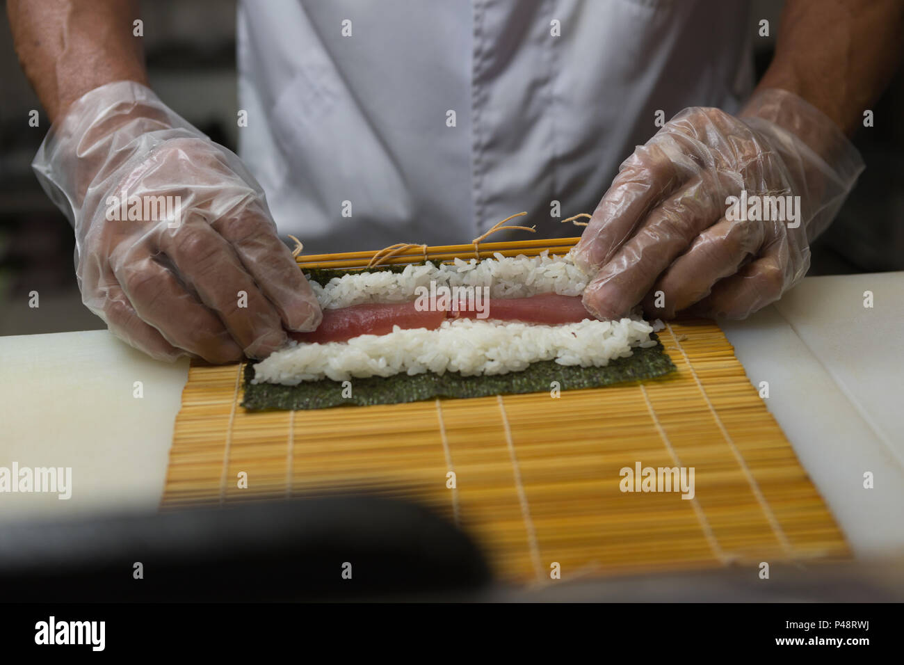 Senior chef preparing sushi in kitchen Stock Photo