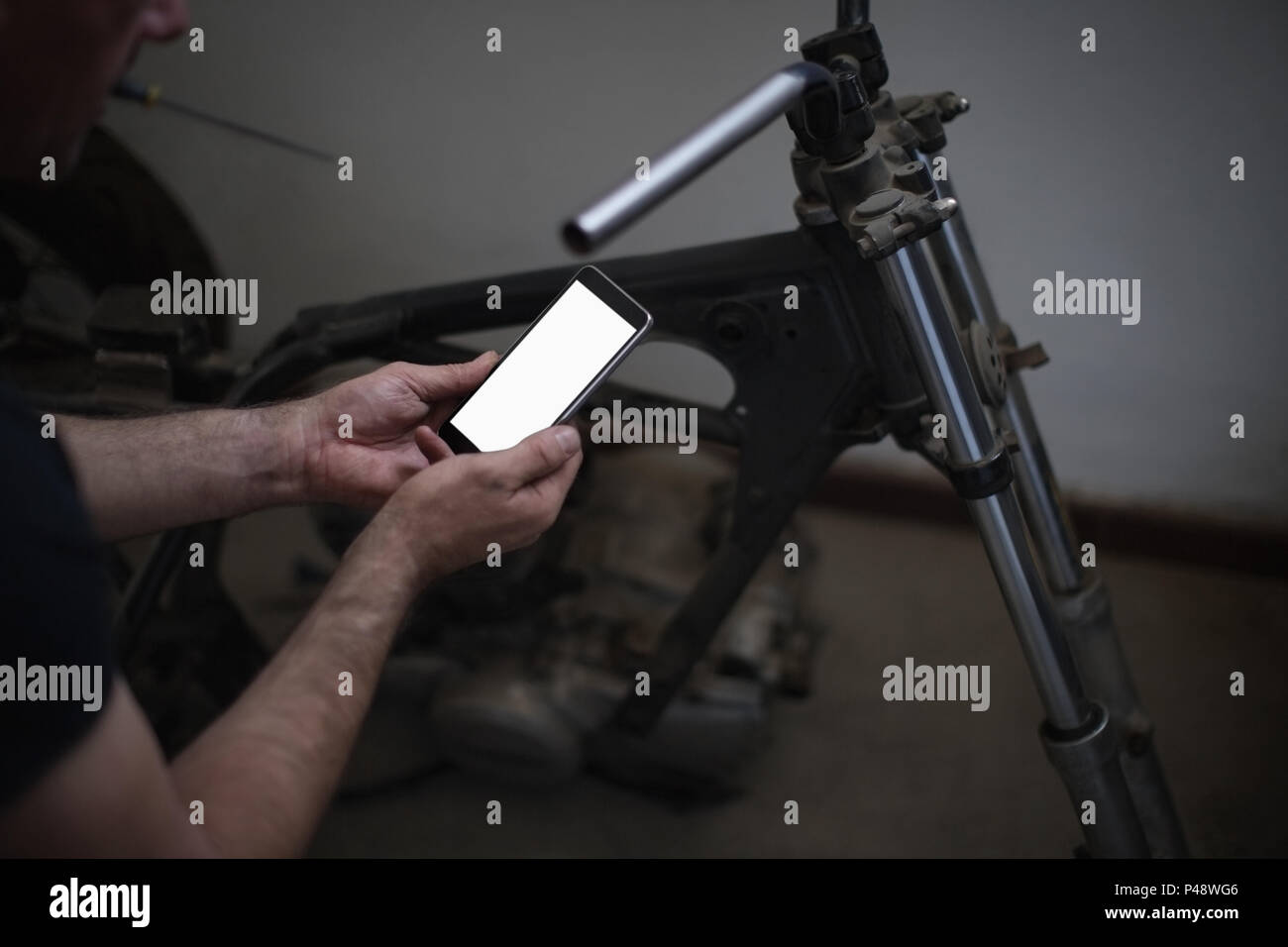 Mechanic using mobile phone Stock Photo