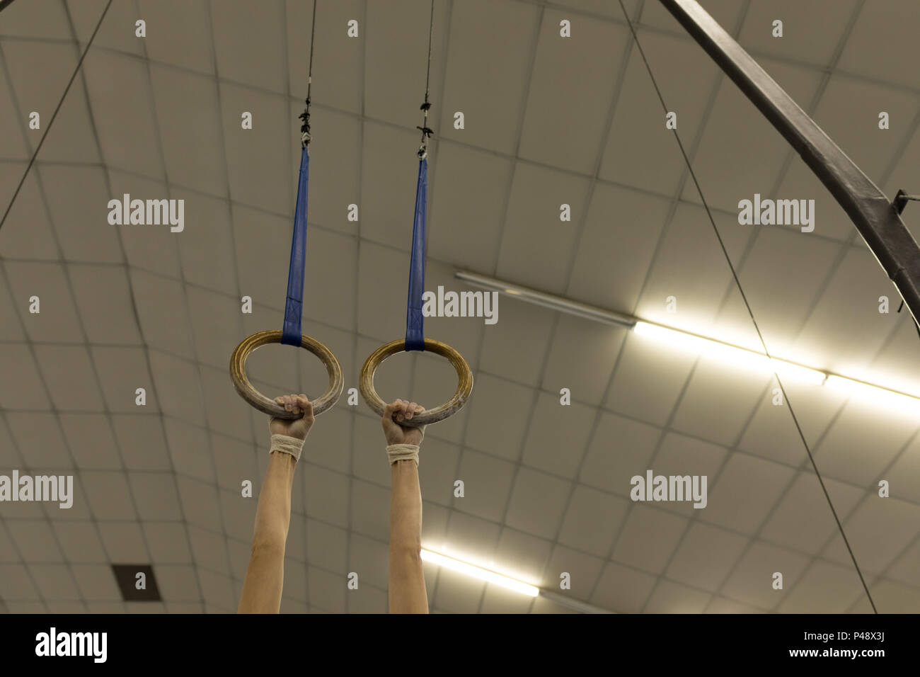 Woman Hanging On Gym Ring At Fitness Studio Stock Photo