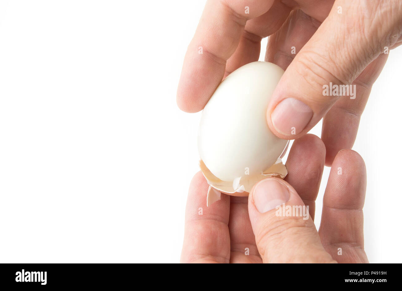 Peeling off the hard egg shell with hands on the white Stock Photo Alamy