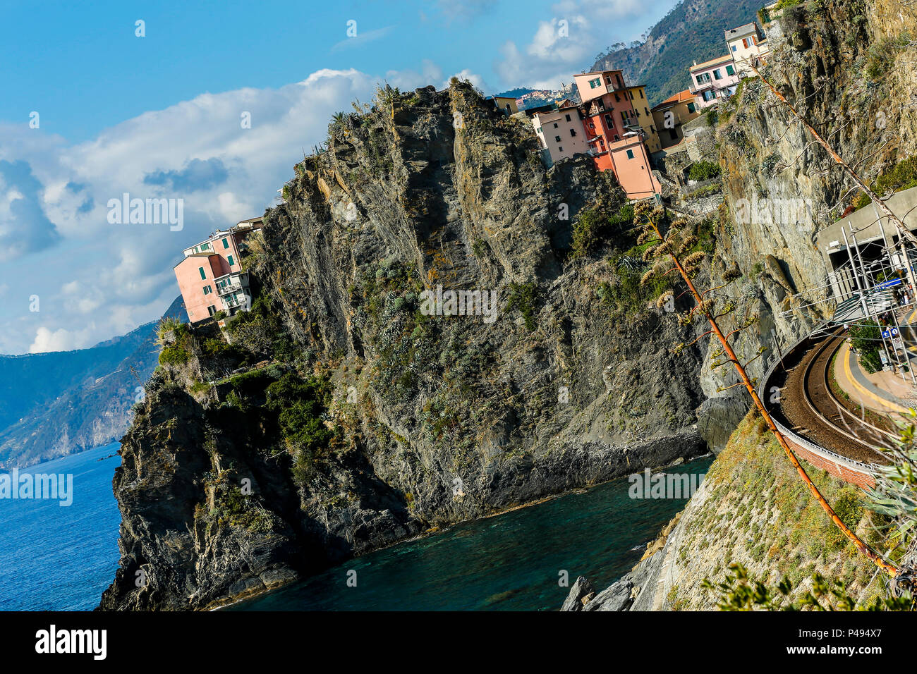 Tilted image of cliffs, sea and colorful cliff-sde homes seen from the train station, Manarola, Cinque Terre Stock Photo