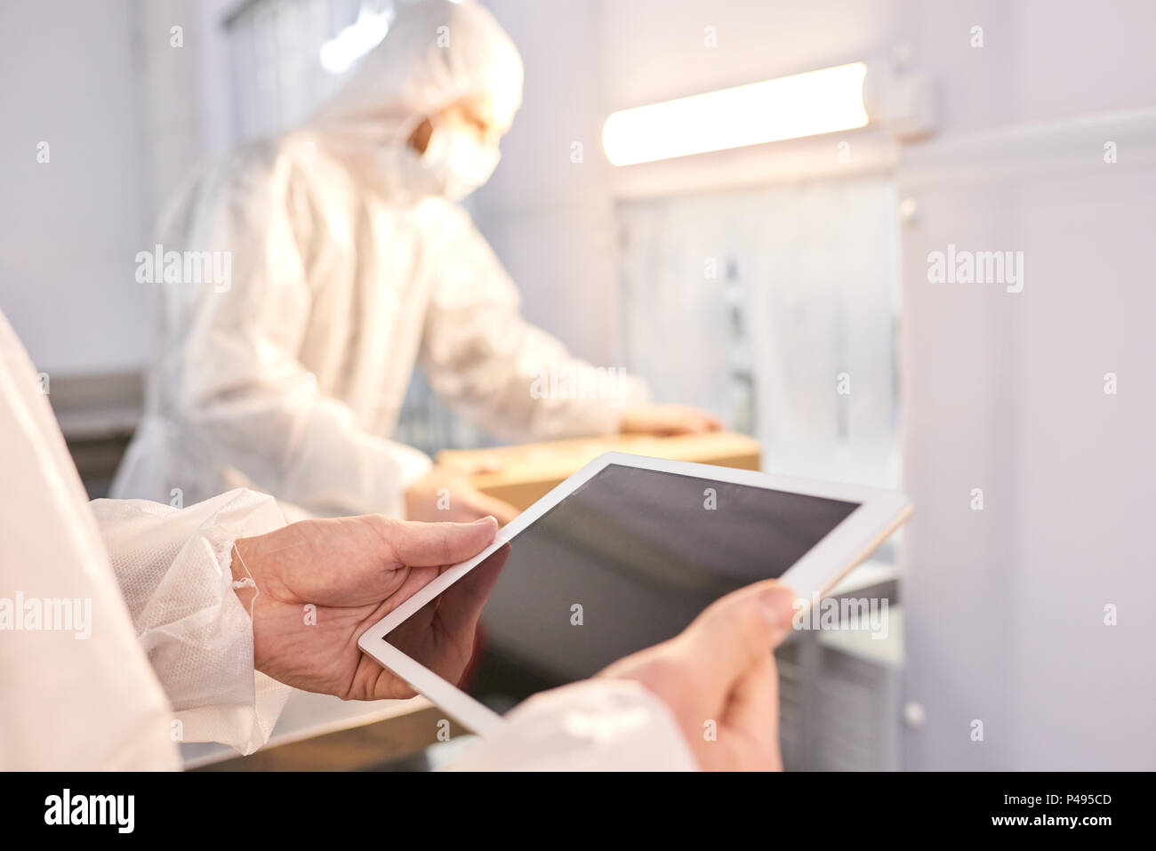 Sports nutrition factory employee using tablet Stock Photo