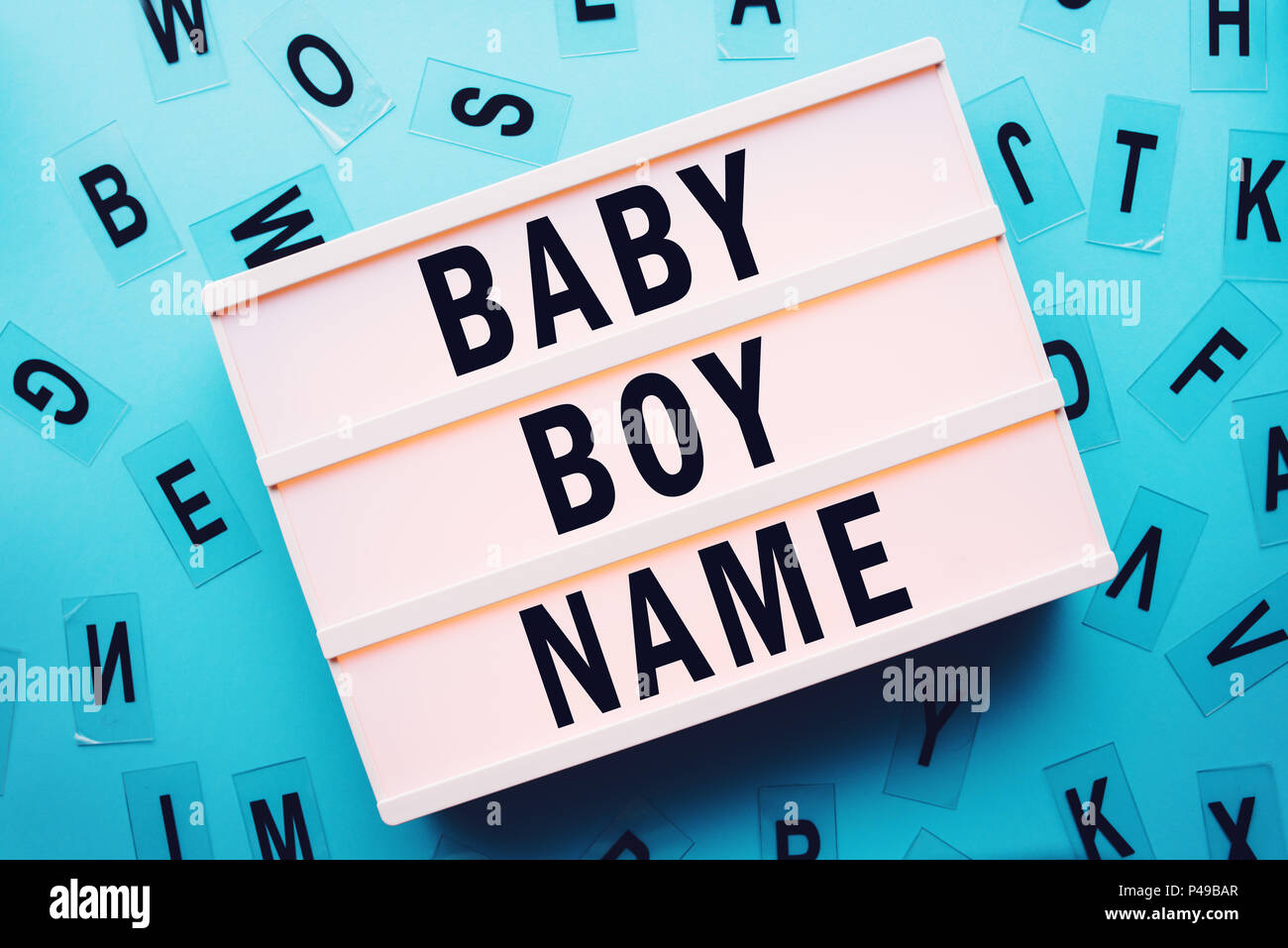 Choosing baby boy name concept with lightbox and various letters scattered around Stock Photo