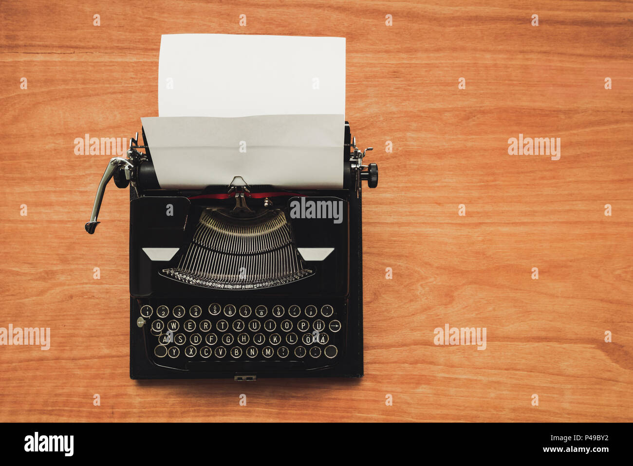 Vintage typewriter machine on writers desk, top view flat lay conceptual image for blogging, publishing, journalism or poetry writing. Stock Photo