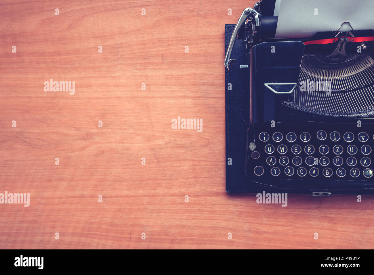 Vintage typewriter machine on writers desk, top view flat lay conceptual image for blogging, publishing, journalism or poetry writing. Stock Photo