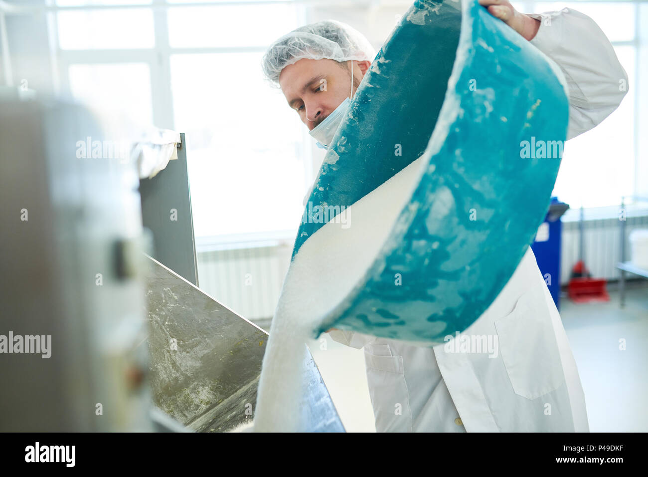 Confectioner poured out sugar in vat Stock Photo