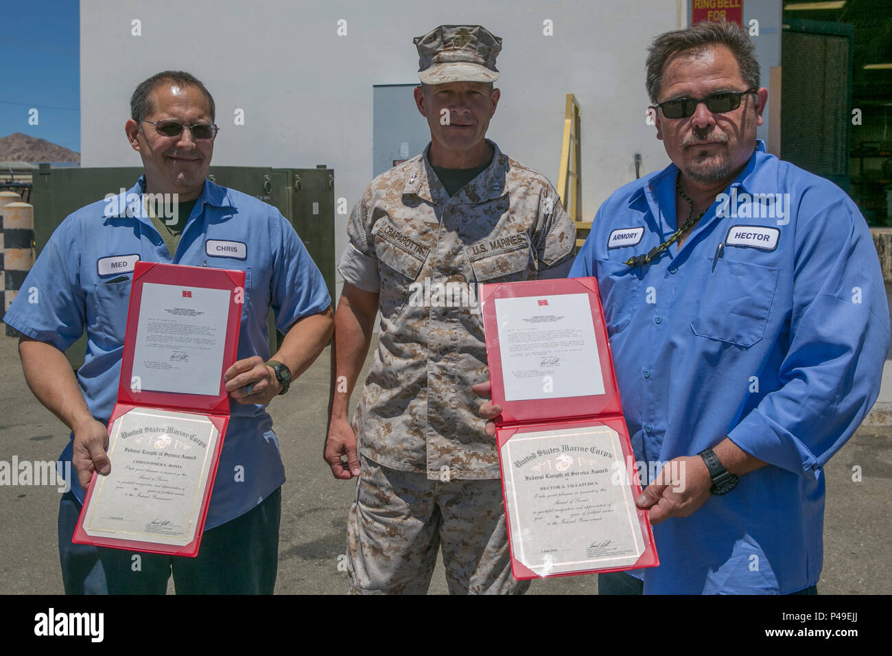 Maj. Gen. Lewis A. Craparotta, Combat Center Commanding General, congratulates Christopher Ronia, motor technician mechanic, and Hector Villapudua, small arms repair and inspector, Exercise Support Division 30 Years of Civilian Service Awards for their achievement of at the ESD compound aboard the Marine Corps Air Ground Combat Center, June 15, 2016. (Official Marine Corps photo by Lance Cpl. Dave Flores/Released) Stock Photo