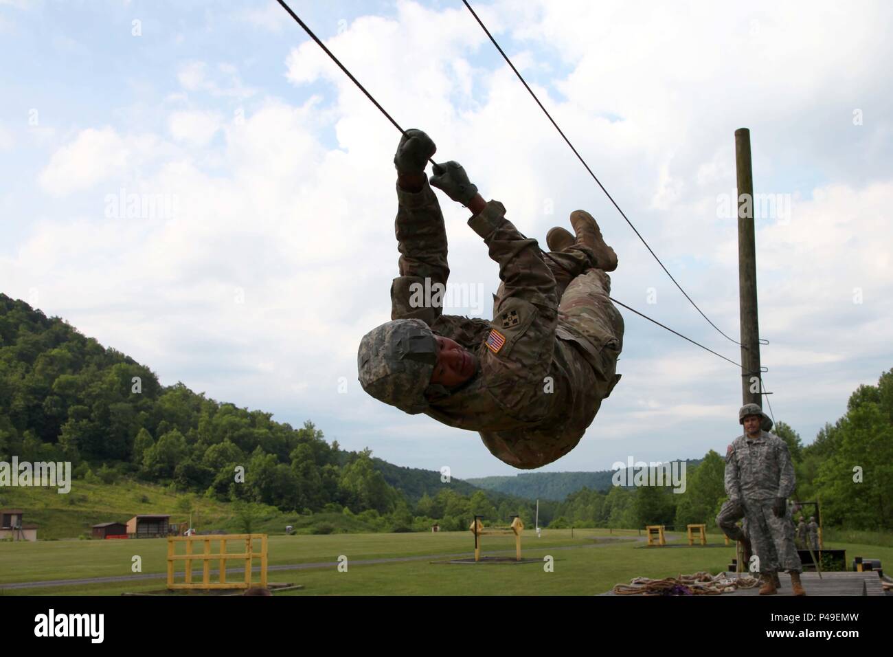 Making his way across a wire obstacle, a psychological operations Soldier works with his team to complete a leader reaction course at Camp Dawson, West Virginia, June 11. During the unit’s mission readiness exercise, 6th Military Information Support Battalion, 4th Military Information Support Group, validated military information support teams that will augment Special Operations Command Europe in the coming months on their tactical tasks, language proficiency and cultural understanding. (U.S. Army photo by Capt. Stephen Von Jett/Released) Stock Photo