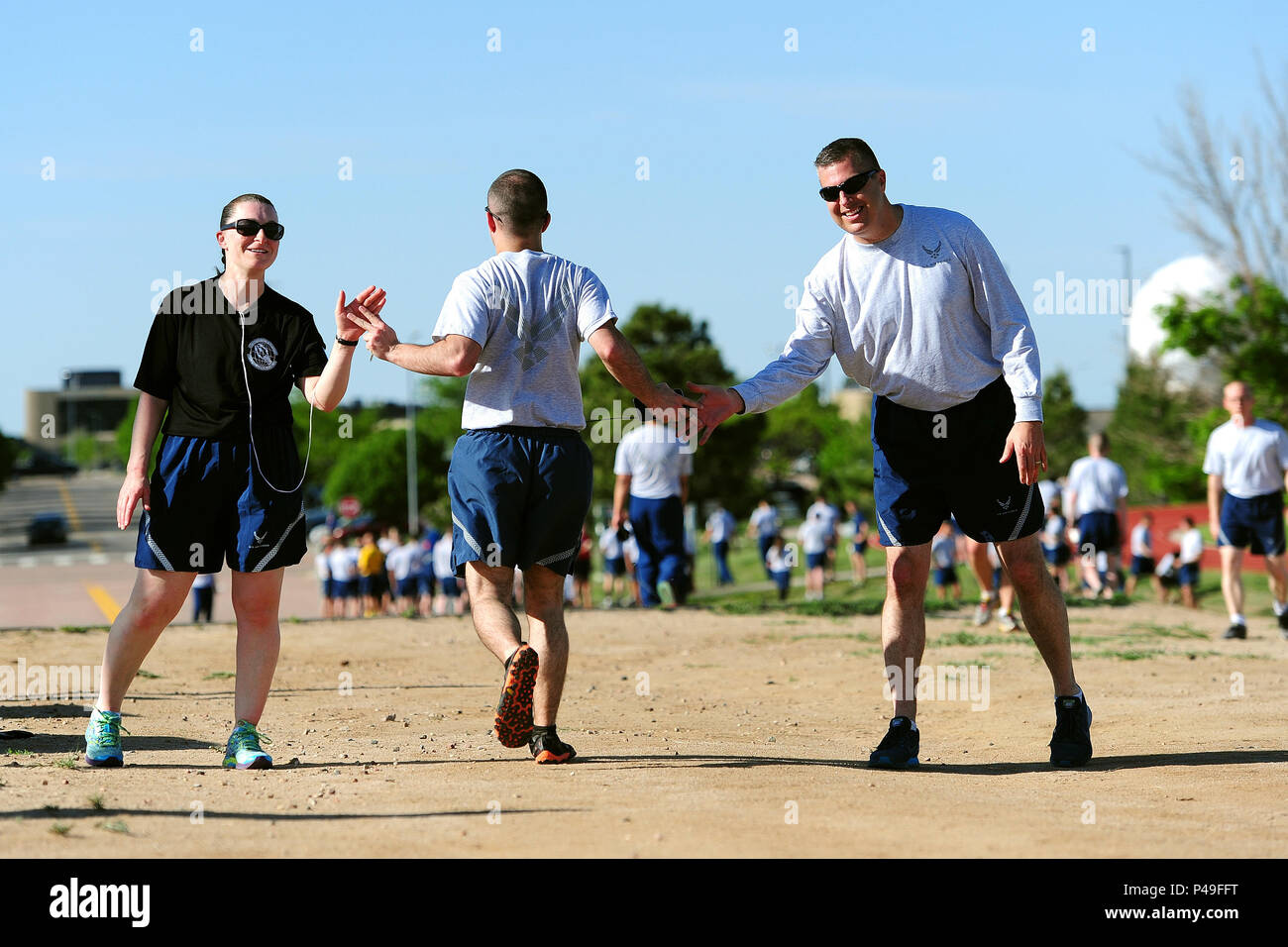 SCHRIEVER AIR FORCE BASE, Colo. -- Senior Master Sergeants Patricia Ford and Patrick Kincaid greet members of the 50th Space Wing as they complete the monthly Warfit Run 8 June 2016.  (U.S. Air Force Photo/Dennis Rogers) Stock Photo