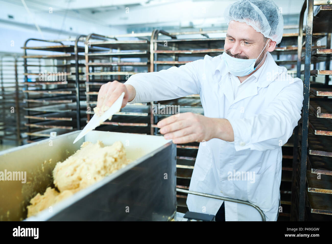 Confectioner mixing dough in factory Stock Photo