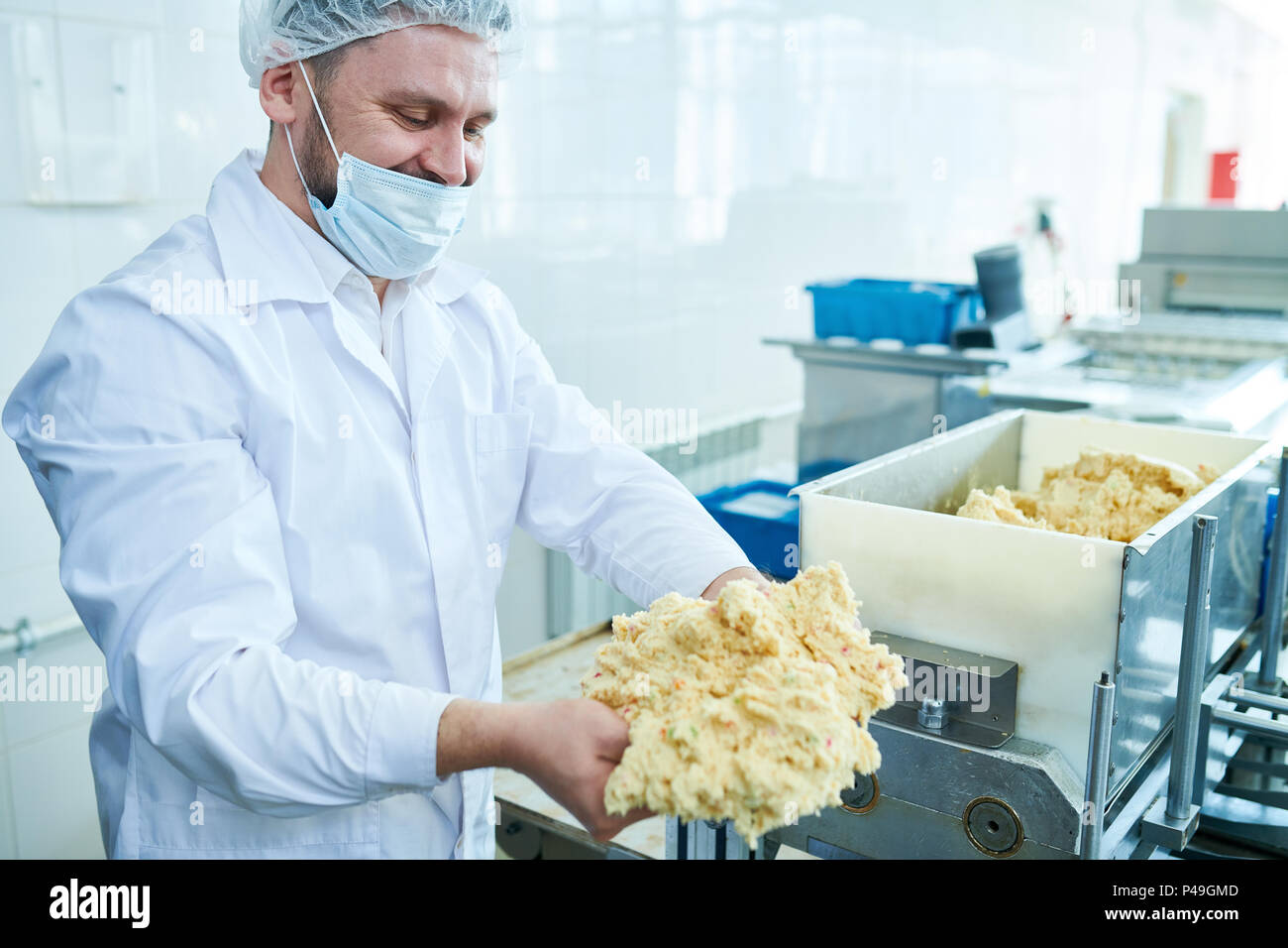 Confectioner in professional uniform holding dough Stock Photo