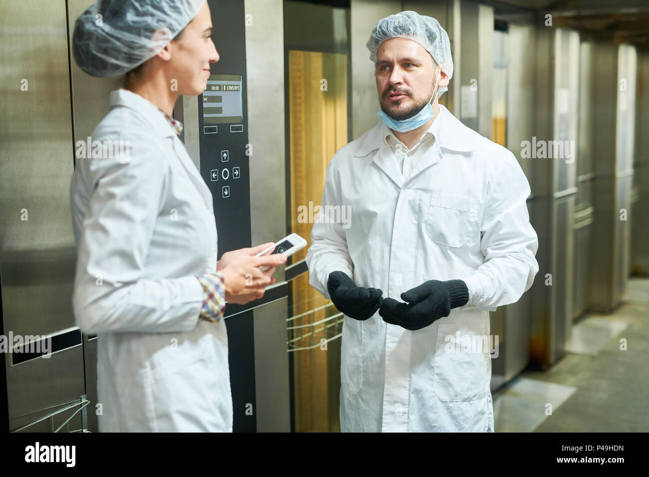People in lab coats talking near elevators Stock Photo