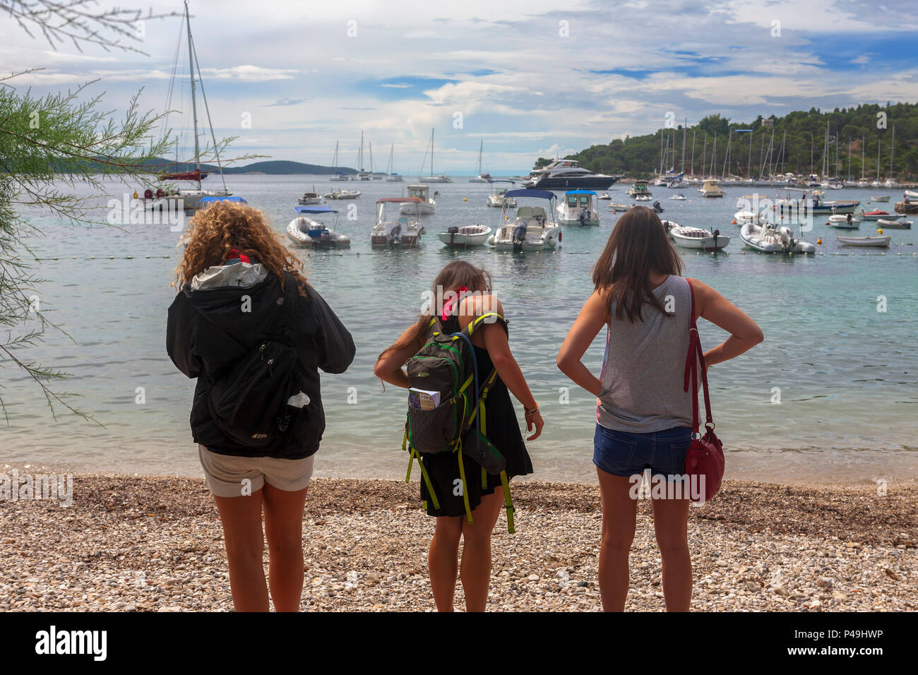 Three girls survey the beach, Hvar, Croatia Stock Photo