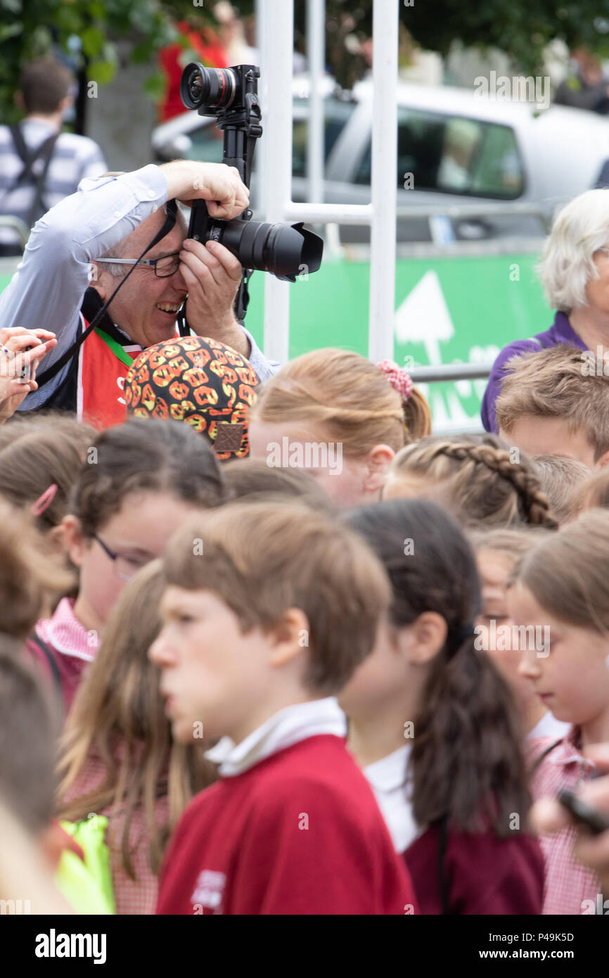 Photographer working at the 2018 OVO Women's Tour with a crowd of school children in the forground Stock Photo