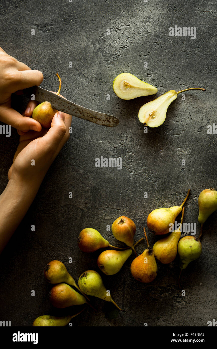 Female Hands Holding Pears on Rustic Dark Background with Copy Space Stock Photo