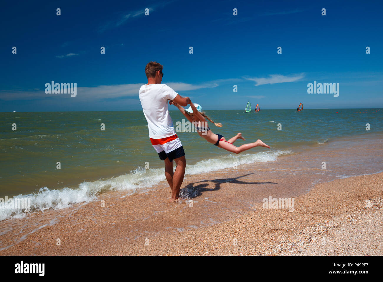 Happy father and his daughter at the beach having fun. Stock Photo