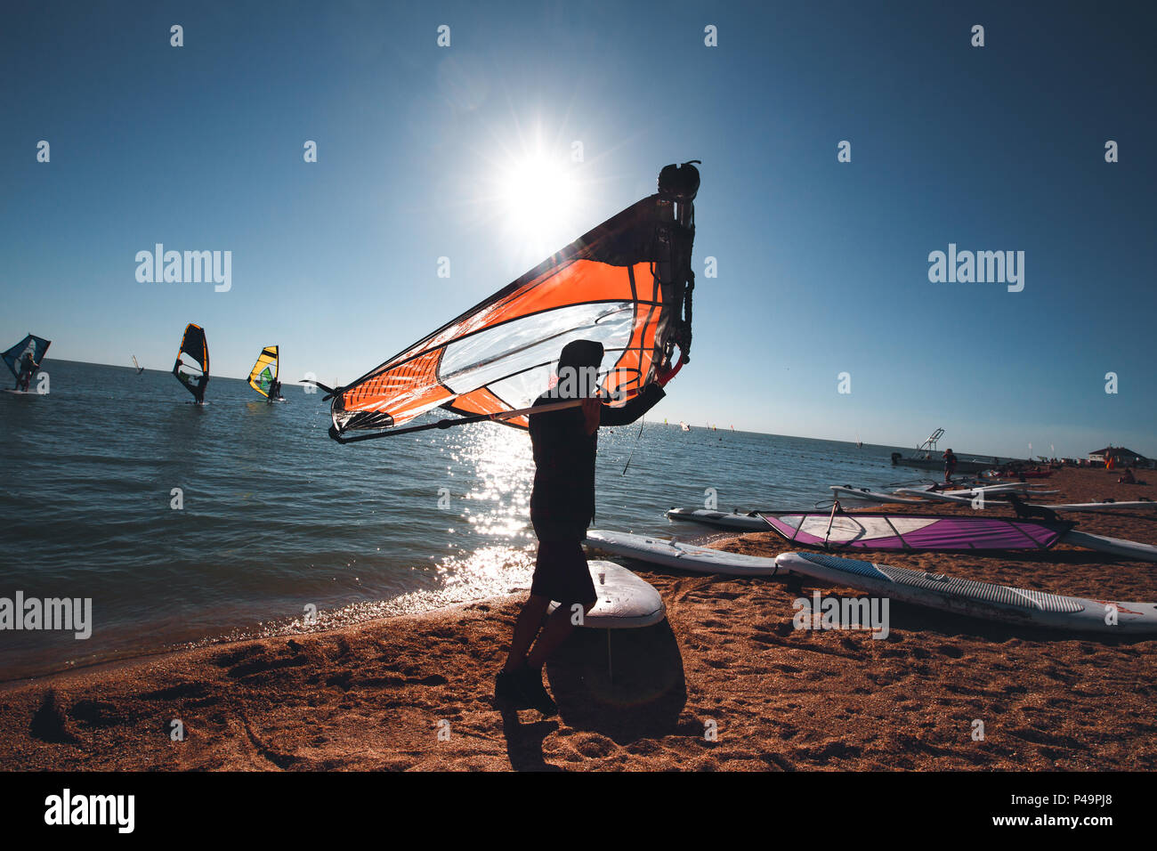 Windsurf boards on the sand at the beach. Windsurfing and active lifestyle. Stock Photo