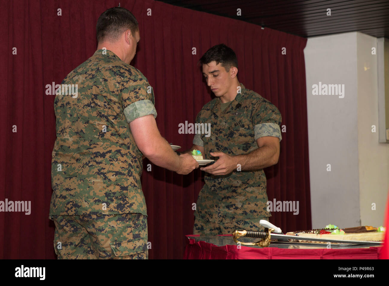 senior chief hospital corpsman mitchell woods left the oldest corpsman present passes a piece of cake to hospital corpsman nicholas vath right the youngest corpsman present during the 118th navy hospital corpsman birthday ceremony aboard morn air base spain june 17 2016 it is traditional for a piece of cake to be passed from the oldest corpsman present to the youngest symbolizing the passage of knowledge and experience from one generation to the next us marine corps photo by staff sgt tia naglereleased P49R63