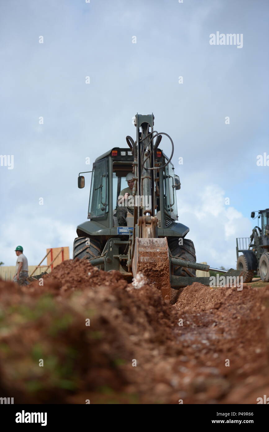 U.S. Air Force Senior Airman Peter Berg with the 157th Civil Engineering Squadron, New Hampshire Air National Guard, digs a trench to help drain water away from a construction site, Andersen Air Force Base, Guam, June 21, 2016. The 157 CES Airmen are deployed to Guam for annual training where they are working on the Commando Warrior Field Training facility, part of an ongoing construction project at the Pacific Command Regional Training Center. (Air National Guard photo by Tech. Sgt. Aaron Vezeau) Stock Photo
