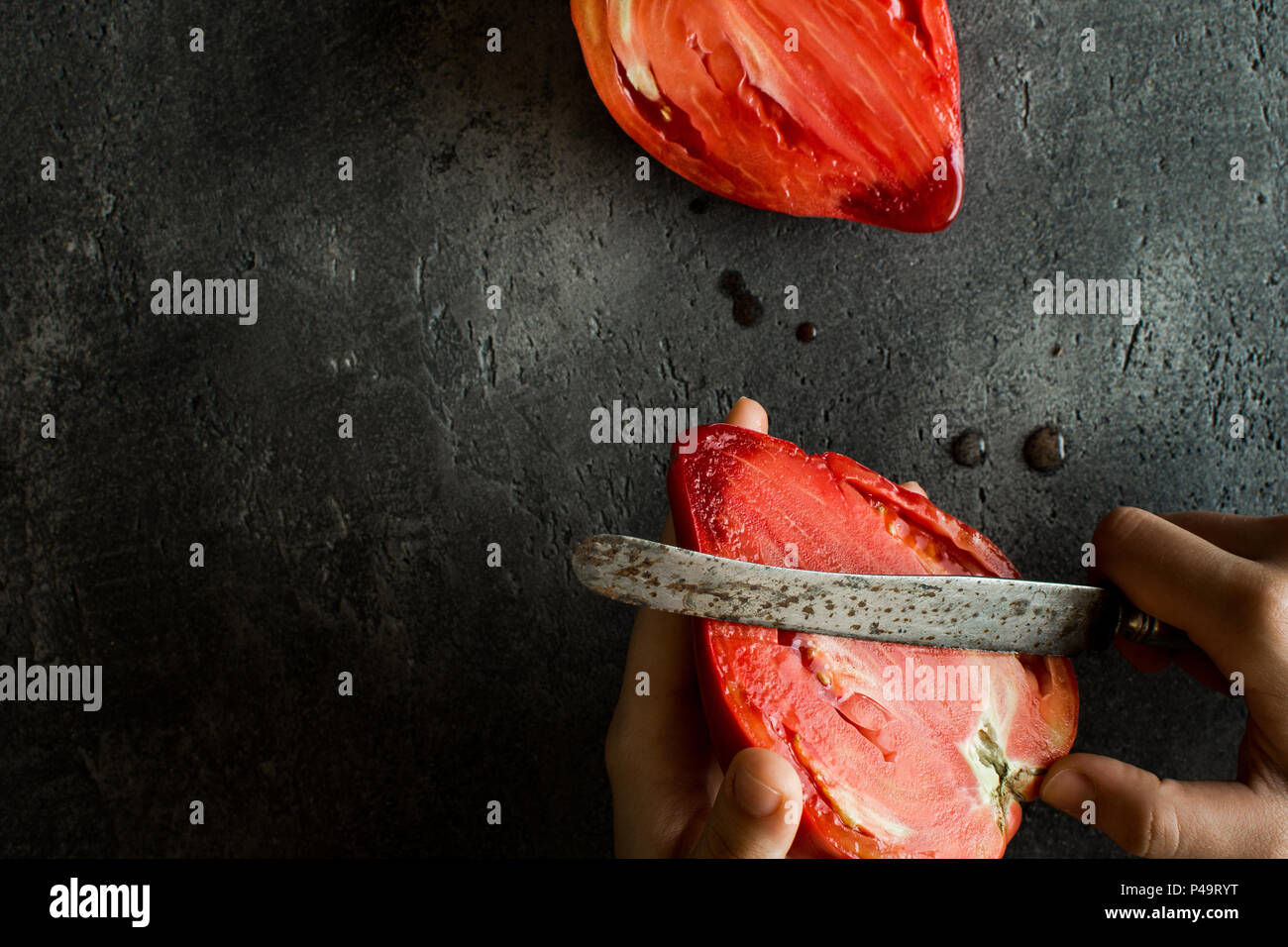 Female Hands Cut Organic Bull's Heart Heirloom Tomato. Superfood Healthy Eating Concept. Stock Photo