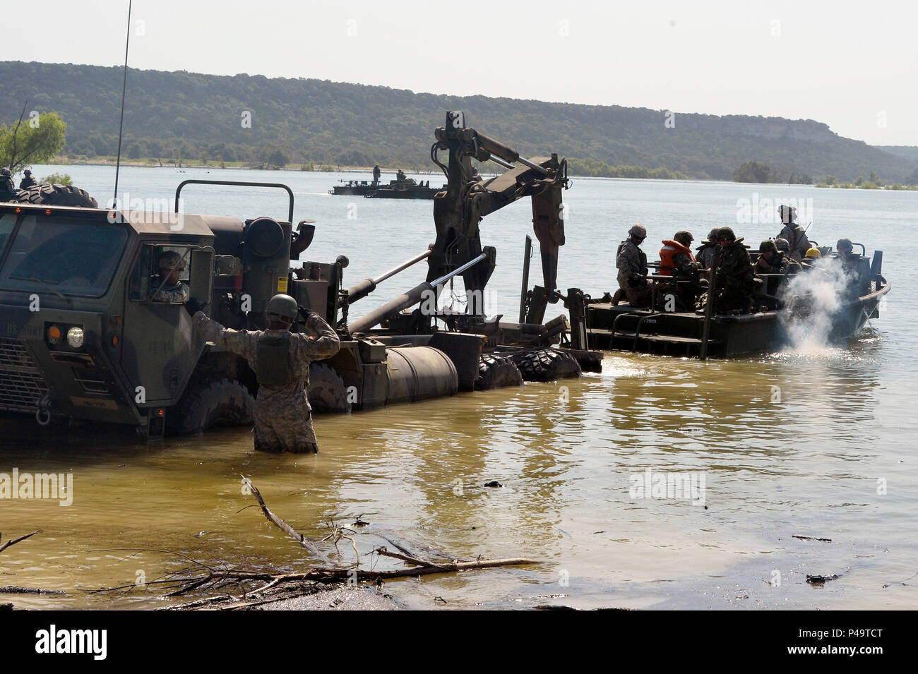 Texas Army National Guardsmen from the 551st Multi Role Bridge Company (MRBC) work together to load boats into the lake as part of a first-time Multinational Lumberjack River Exercise, June 21, 2016, Fort Hood, Texas. During the exercise, service members from the Texas National Guards 386th Engineer Battalion, 551st MRBC, and the Czech Republic will conduct a Wet Gap Crossing to transport military vehicles across Lake Belton. (U.S. Army National Guard photo by Sgt. Elizabeth Pena/Released) Stock Photo