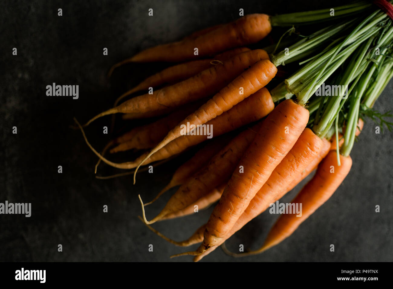 Organic Nantes Carrots on Rustic Dark Background. Fresh Superfood Healthy Eating Concept. Stock Photo