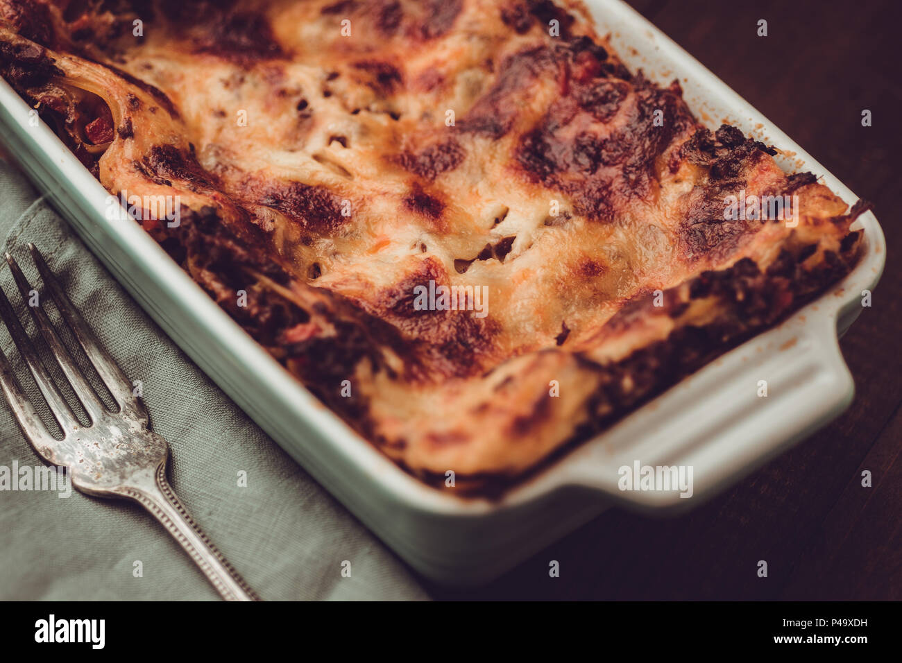 Italian Lasagna Bolognese and Mozzarella Cheese on Dark Wooden Background Stock Photo