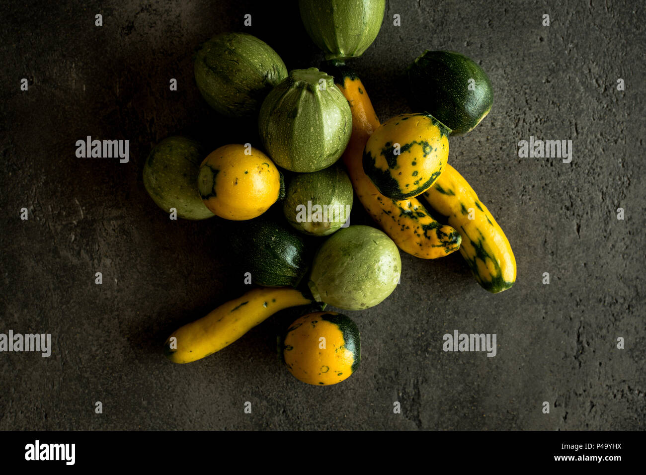 Yellow and Green Round Zucchini on Rustic Dark Background Stock Photo