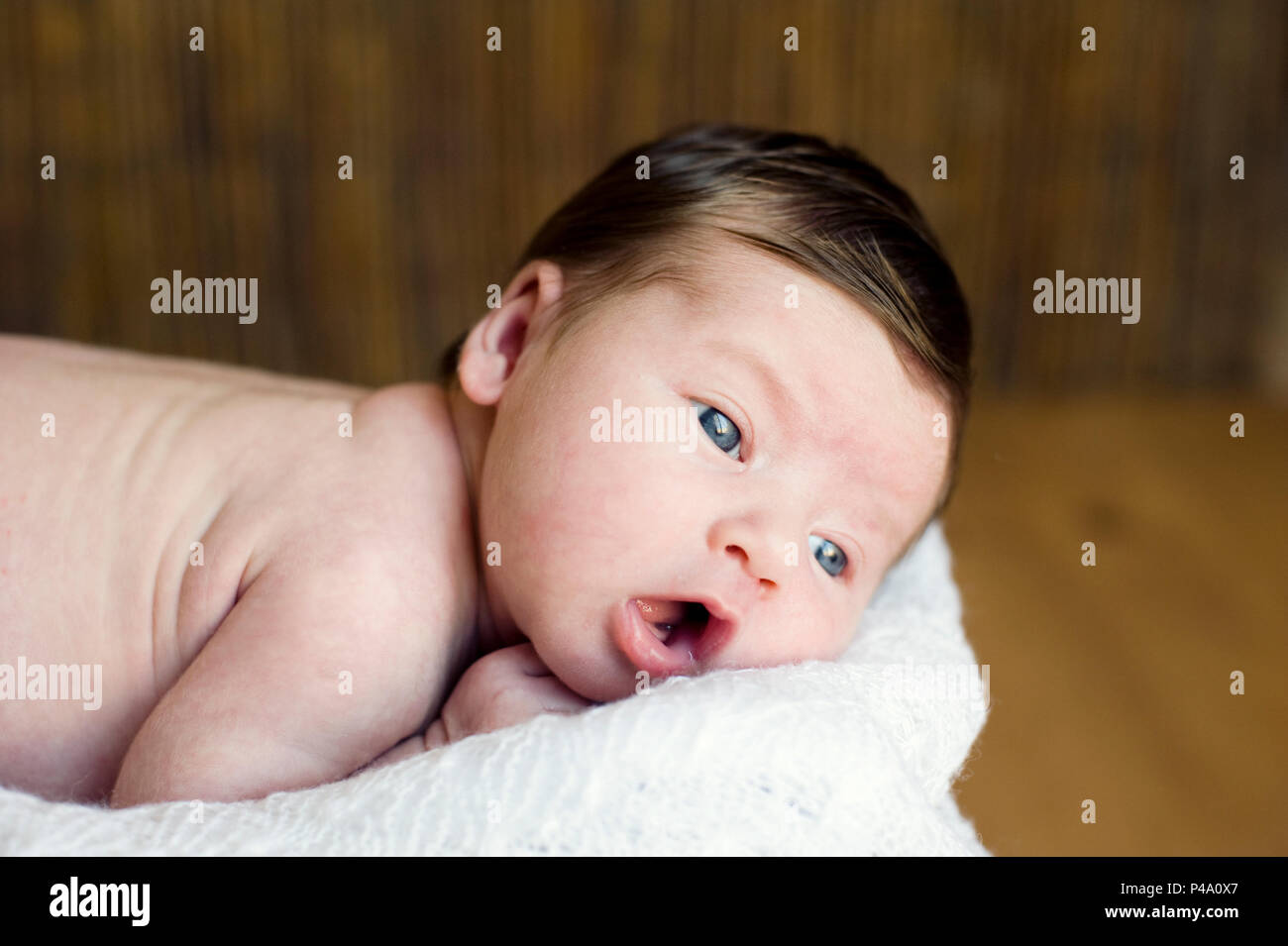 Adorable beautiful newborn baby looking up with a look of wonderment. Stock Photo