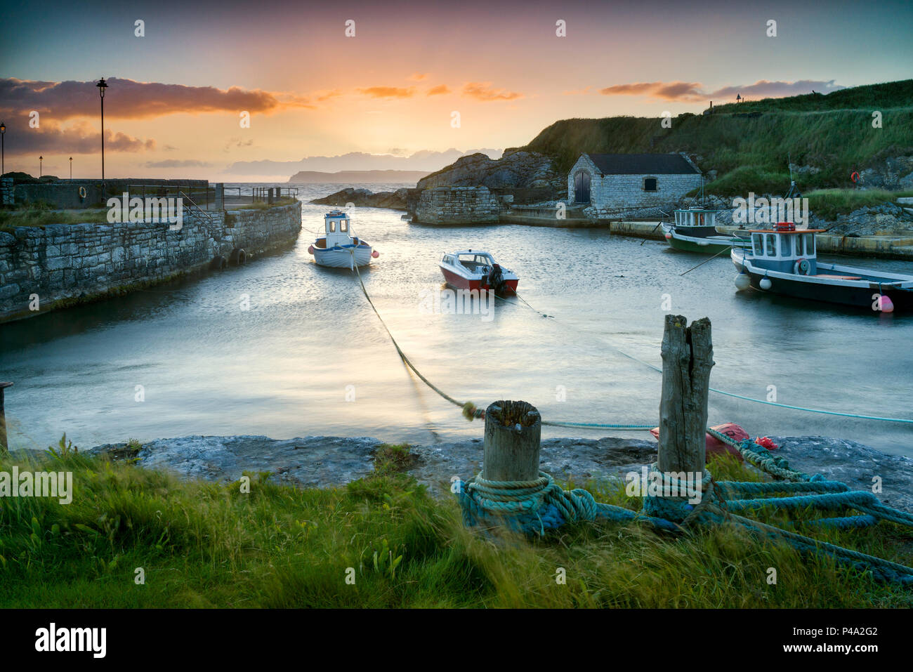 Ballintoy, County Antrim, Northern Ireland, UK. 21st June, 2018. Summer solstice morning. UK Weather, a clear sunrise on the longest day of the year. Daybreak over Ballintoy harbour and Rathlin Island, on the Causeway Coast, North Antrim, Northern Ireland. Credit: John Potter/Alamy Live News Stock Photo