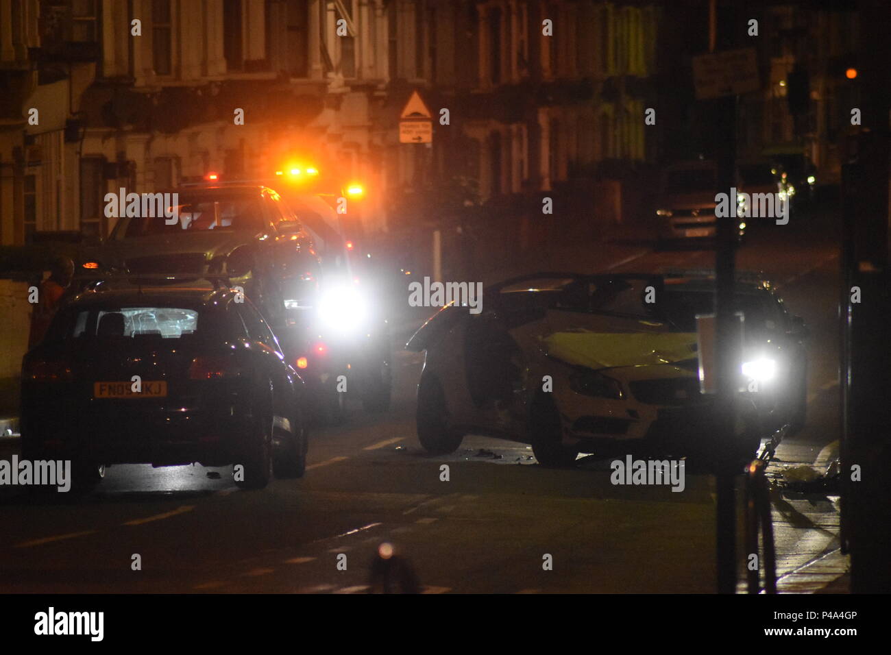 Walthamstow, London, UK. 21st June, 2018. A high speed collision leaves two cars devastated on a street in Walthamstow. There were no fatalities at the scene of the accident. It's apparent that the roof of one of the vehicles has been cut off with the jaws of life to remove a driver but no severe injuries were reported at this time. A tow truck removes one of the vehicles involved as the second waits to be removed also. Credit: Ricardo Maynard/Alamy Live News Stock Photo