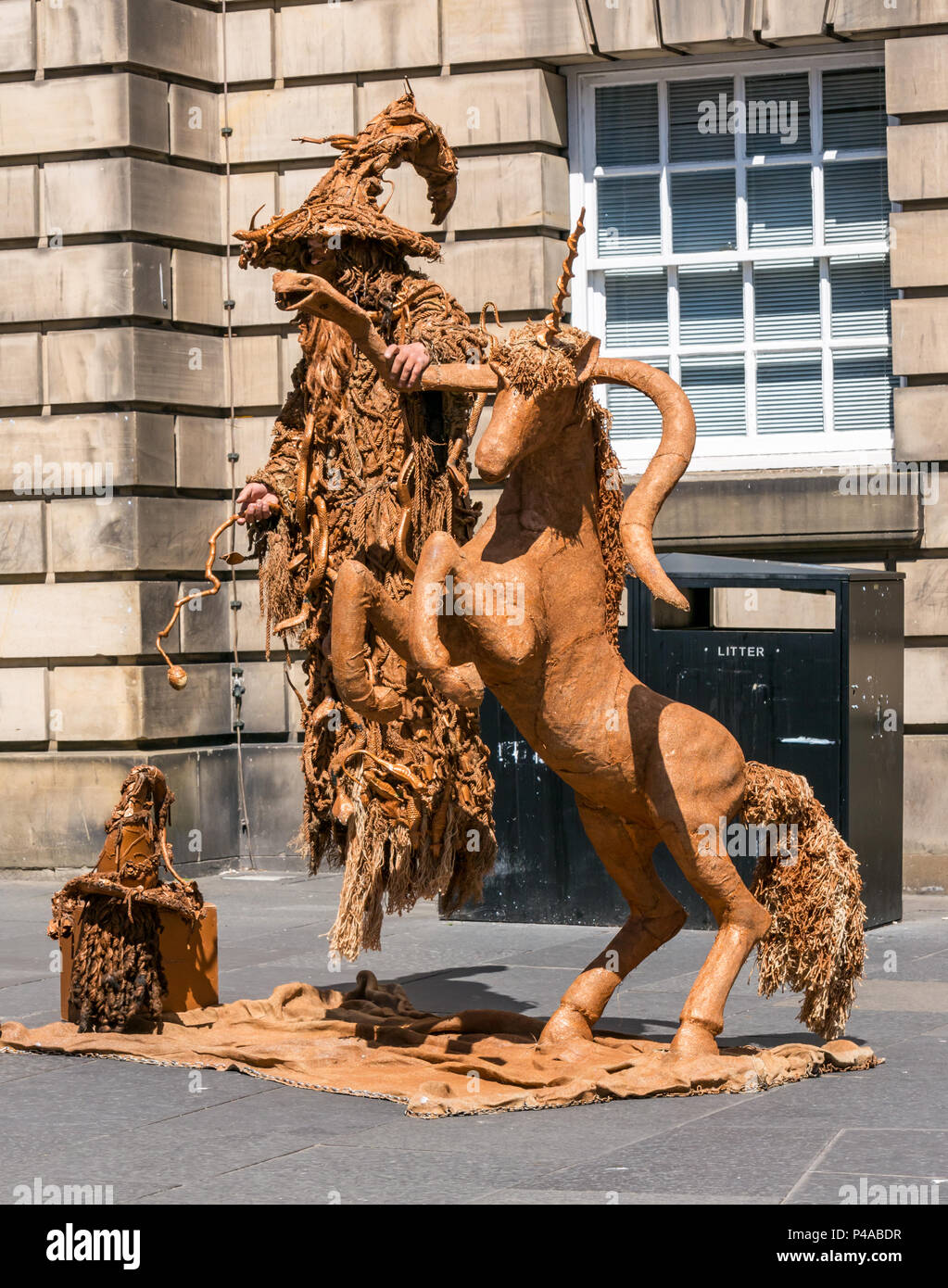 Edinburgh, Scotland, United Kingdom, 21st June 2018. A street performer in a levitation act dressed as a living statue of Gandalf the Wizard with a unicorn to entertain passers by on the Royal Mile during the Summer season Stock Photo