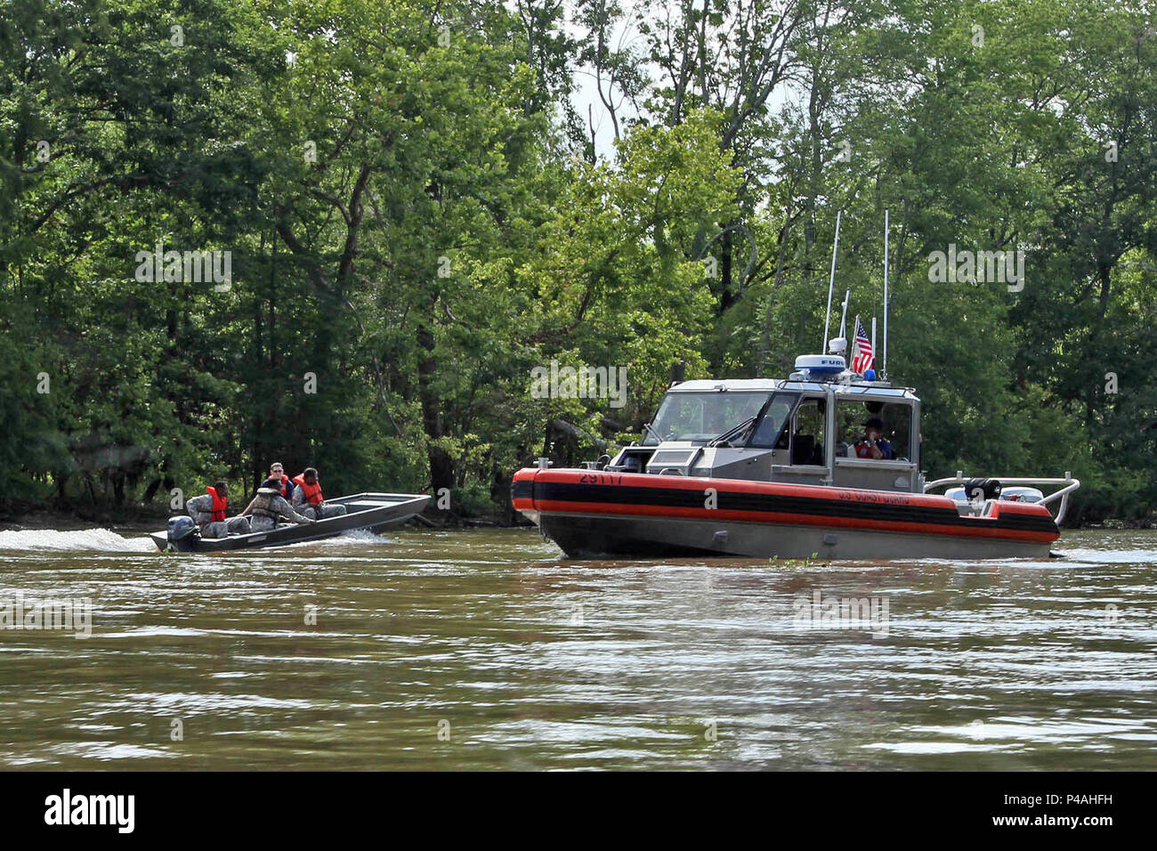 A Soldier of the Louisiana National Guard's 832nd Engineer Utilities  Detachment pulls a water-rescue training dummy from the waters of Bayou  Sorrel under the supervision of U.S. Coast Guard Auxiliary member from