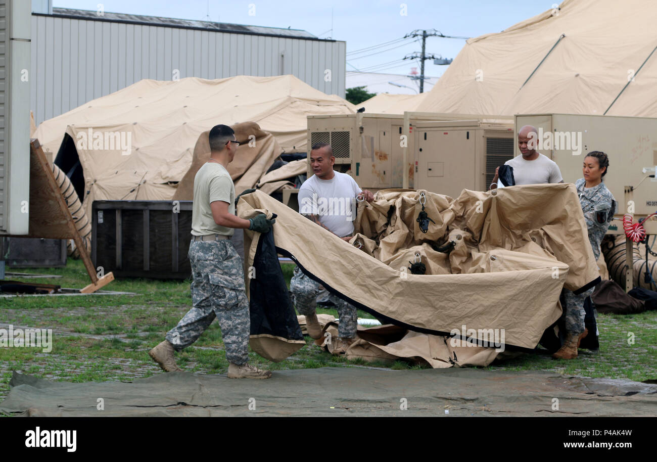 U.S. Army Reserve Soldiers of the Pacific, 303rd Maneuver Enhancement Brigade, 9th Mission Support Command, relocates a portion of a Deployable Rapid Assembly Shelter in support of break-down operations during exercise Imua Dawn 2016, Sagamihara Depot, Kanagawa, Japan, June 24, 2016.  Imua Dawn 2016 focused on maneuver support operations and enhancing cooperative capabilities in mobility, Humanitarian Assistance and Disaster Relief (HADAR), Noncombatant Evacuation Operations (NEO), and sustainment support in the event of natural disasters and other crises that threaten public safety and health Stock Photo