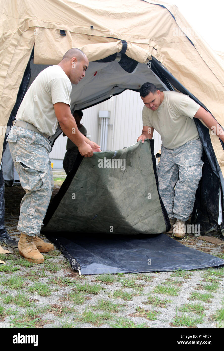 Abraham F. Seei and Salesi M. Fifitaatkins, human resources specialists, 303rd Maneuver Enhancement Brigade, 9th Mission Support Command, ‘wrap up’ portions of the Headquarters and Headquarters Company's Deployable Rapid Assembly Shelter in support of break-down operations during exercise Imua Dawn 2016, Sagamihara Depot, Kanagawa, Japan, June 25, 2016.  Imua Dawn 2016 focused on maneuver support operations and enhancing cooperative capabilities in mobility, Humanitarian Assistance and Disaster Relief (HADAR), Noncombatant Evacuation Operations (NEO), and sustainment support in the event of na Stock Photo