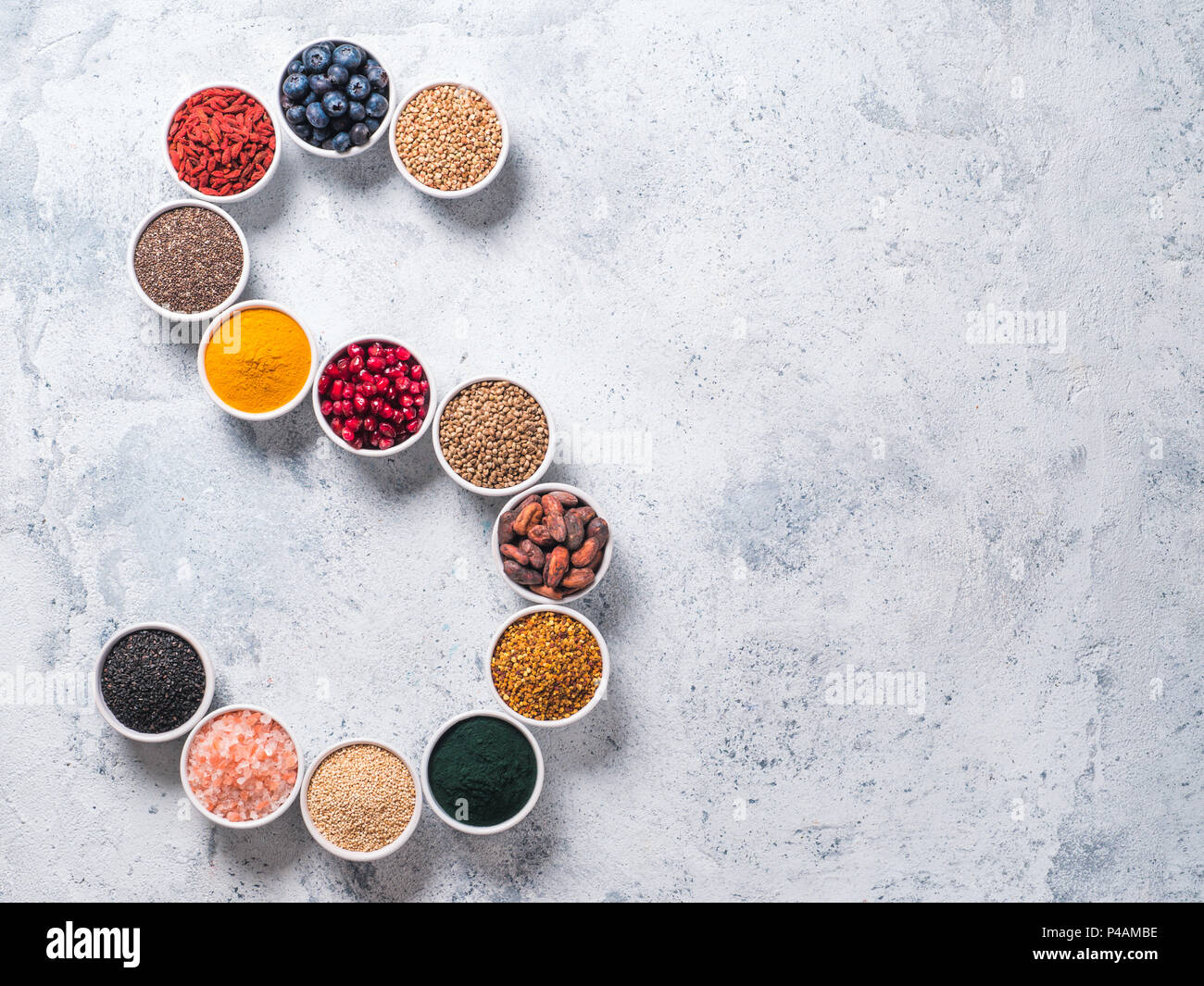 Above view of various superfoods in smal bowl in form S letter on gray