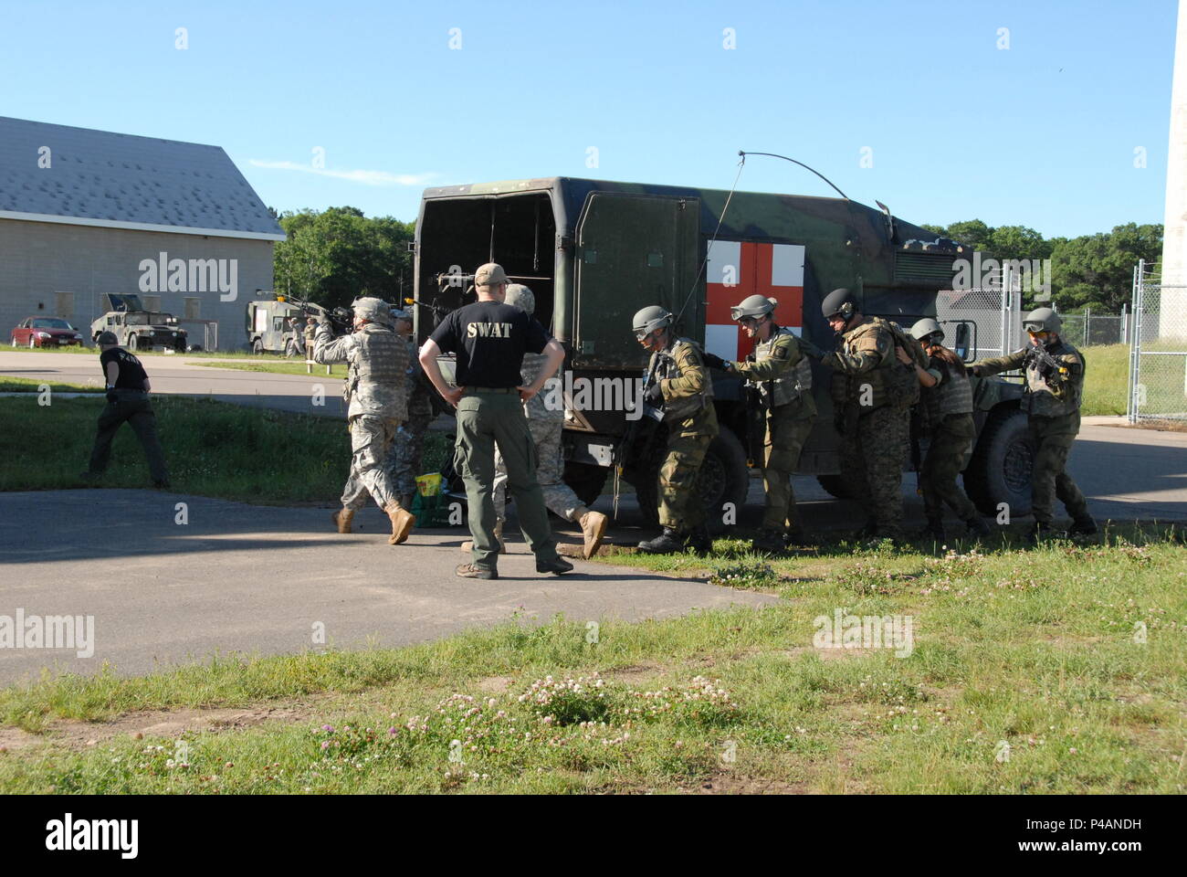 During a culminating event, Soldiers of the Minnesota National Guard and the Norwegian Home Guard conduct squad movements under supervision of local Minnesota law enforcement officers after two days of domestic operations training conducted at Camp Ripley June 24-26. Several law enforcement agencies participated in the event including police officers who are a part of SWAT teams from St. Cloud, East Metro and Morrison, Sherburne and Washington Counties. (Minnesota National Guard Photo by Master Sgt. Ashlee J. L. Sherrill) Stock Photo