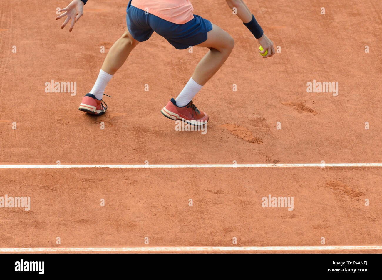 Ball boy picking up, holding the tennis ball, running on a tennis court