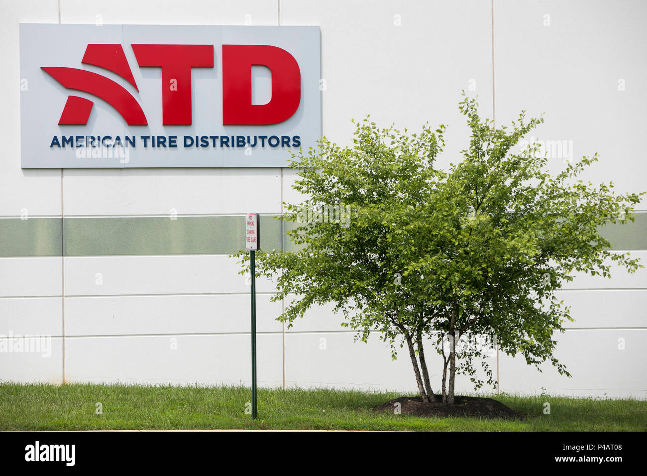 A logo sign outside of a facility occupied by American Tire
