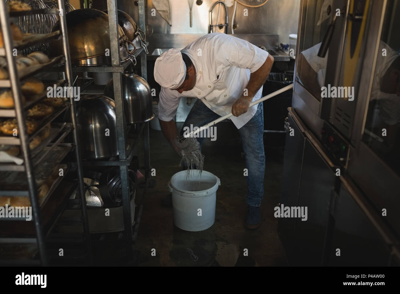 Male baker cleaning floor with floor mop Stock Photo Alamy