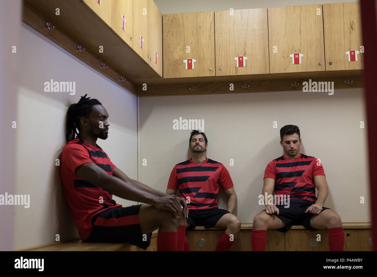 Football players relaxing on bench Stock Photo