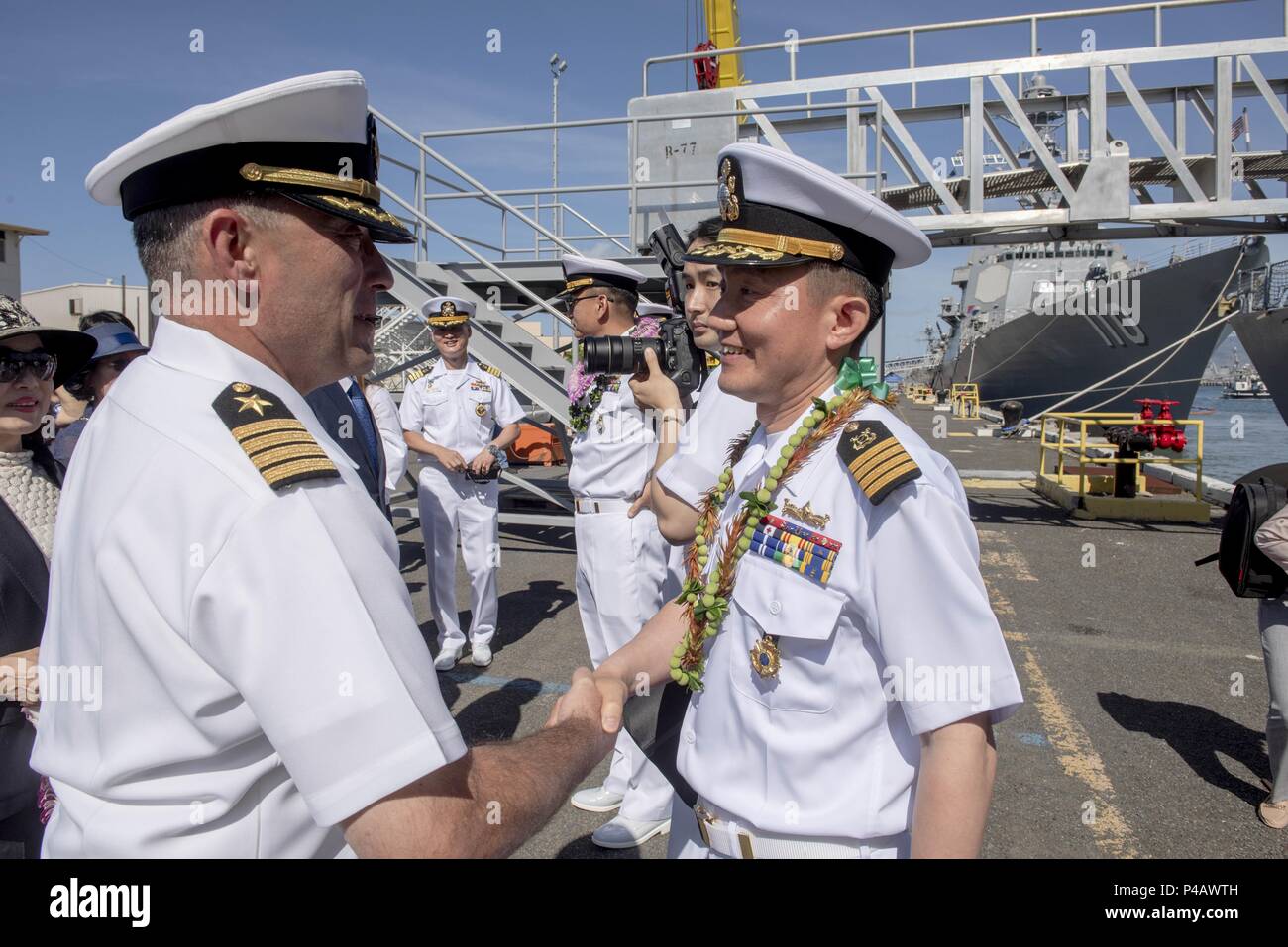 180608-N-QE566-0007 PEARL HARBOR -- (June 8, 2018) Capt. Christopher J. Budde, commanding officer, USS Port Royal (CG 73), left, welcomes Capt. In-Ho Kim, the commanding officer of the Republic of Korea Navy ship Yulgok Yi I (DDG 992), following the ship's arrival to Joint Base Pearl Harbor-Hickam June 8 in preparation for the Rim of the Pacific (RIMPAC) Exercise 2018, June 8, 2018. Twenty-six nations, 47 ships, five submarines, about 200 aircraft, and 25, 000 personnel are participating in RIMPAC from June 27 to Aug. 2 in and around the Hawaiian Islands and Southern California. The world's la Stock Photo